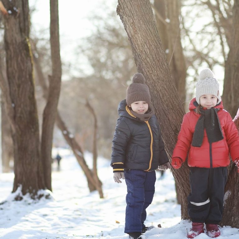 two children standing in the snow