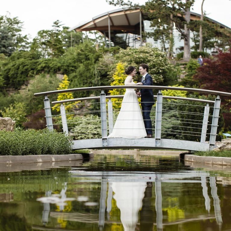 Bride and Groom posing on Bridge at Rock Garden