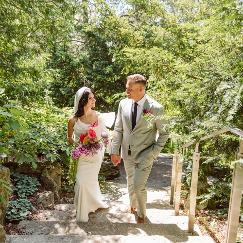 Sophia and Adam Wedding Bride and Groom walking up stone staircase at rock garden