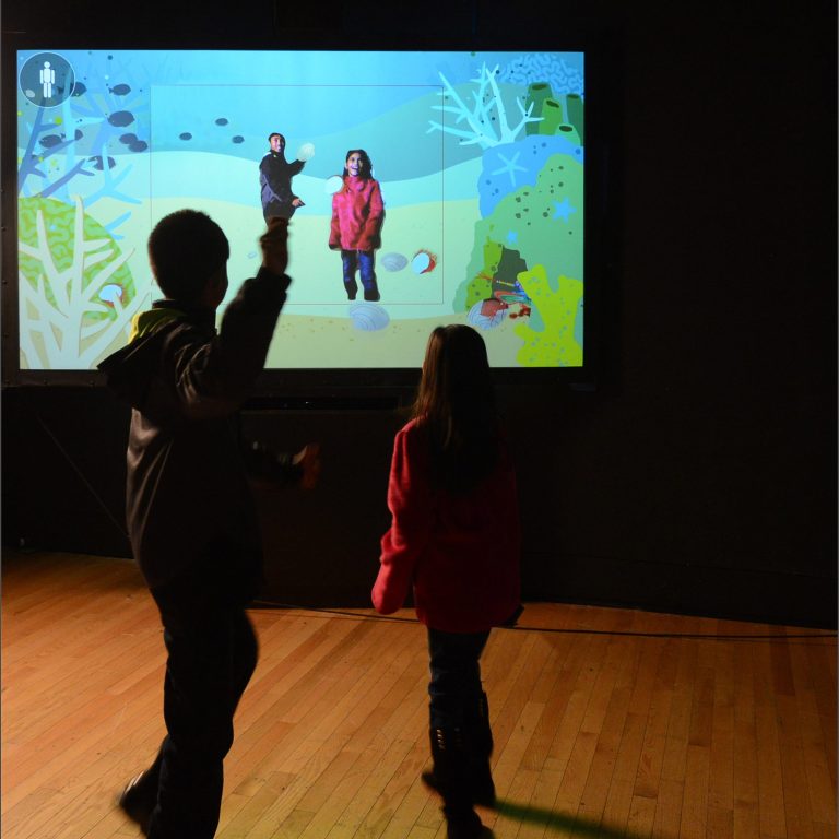 visitors testing their superpowers as part of an exhibit interactive