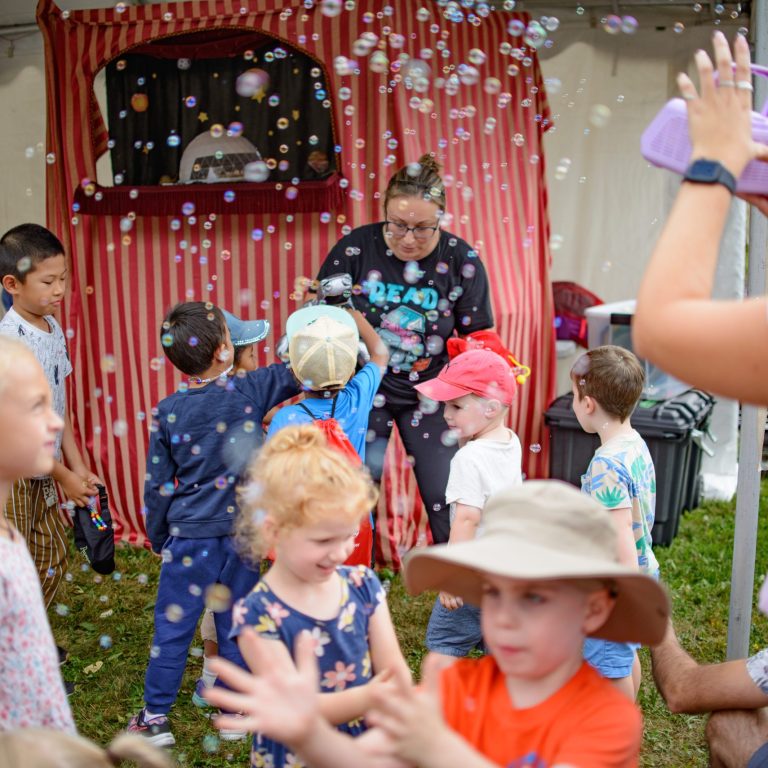 group of children playing in a cloud of bubbles