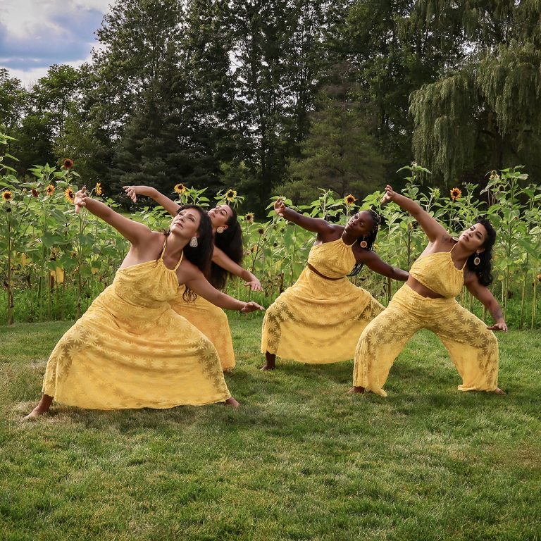 Indigenous dancers performing in a ring of sunflowers
