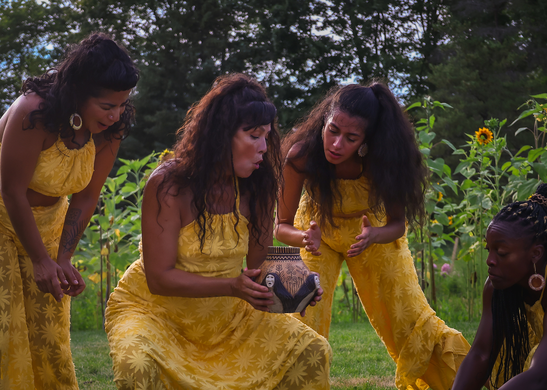 Beings of Light - Skybeings Pot Indigenous dancers performing in a ring of sunflowers, holding a Skybeings Pot