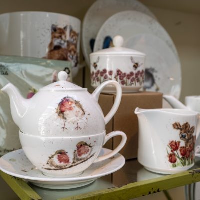 Pottery with watercolour animal motifs displayed in the Garden Shop