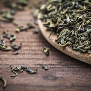 Green-tea-leaves-on-wooden-table Dried Green Tea Leaves