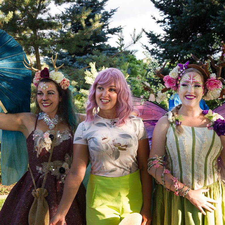 woman posing with two actors dressed as fairies in the Rock Garden