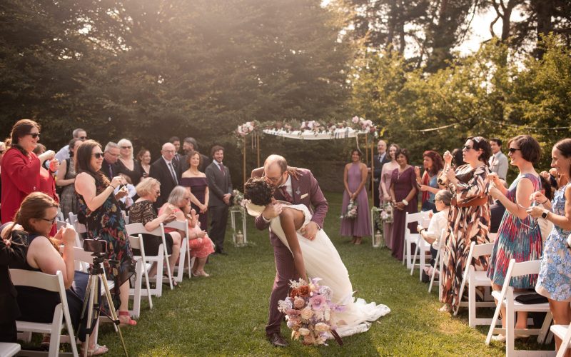 groom dipping bride while walking up the aisle during wedding ceremony in Rock Garden Hamilton Ontario
