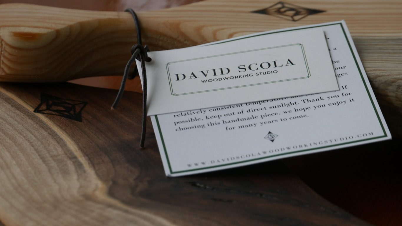 Close up of David Scola's name tag on a handcrafted wooden board