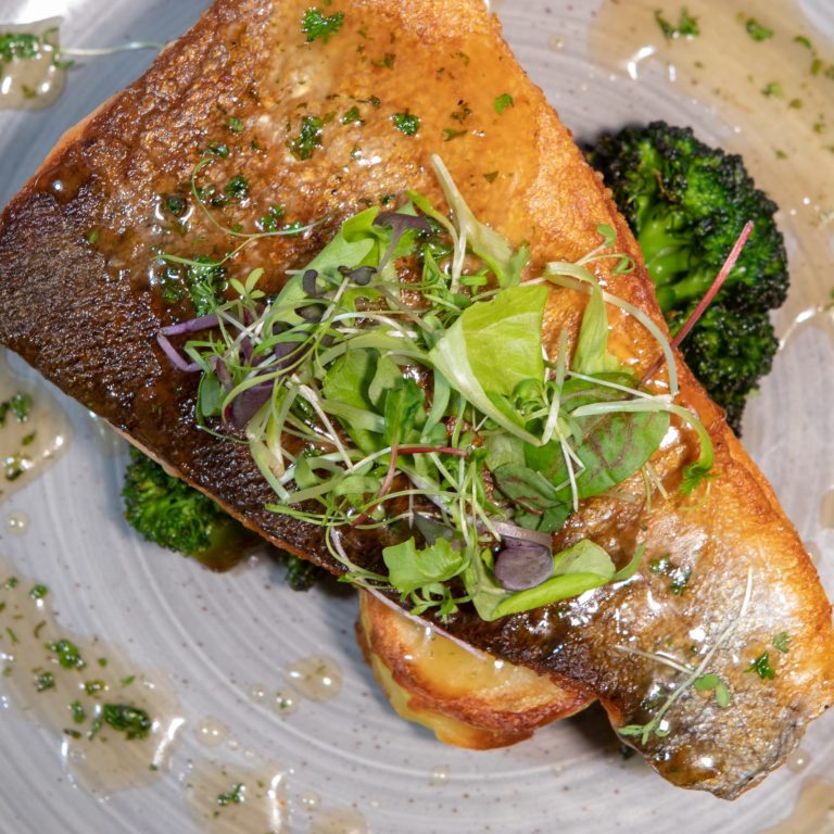 fish plated with broccoli and microgreens