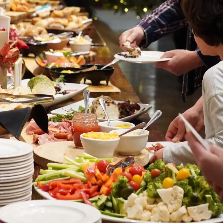 family at a buffet brunch filling their plates with pastries fruits and veggies