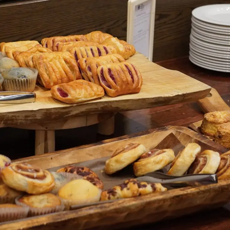 selection of breakfast pastries on wooden risers at a buffet brunch