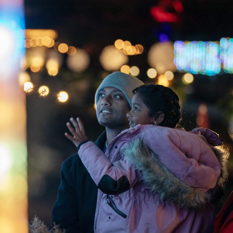 Parents and young child admiring the bright light display at Winter Wonders.