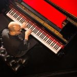 aerial photo above adrean playing a grand piano
