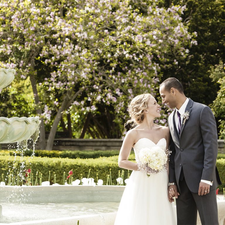 Bride and groom in scented garden beside fountain