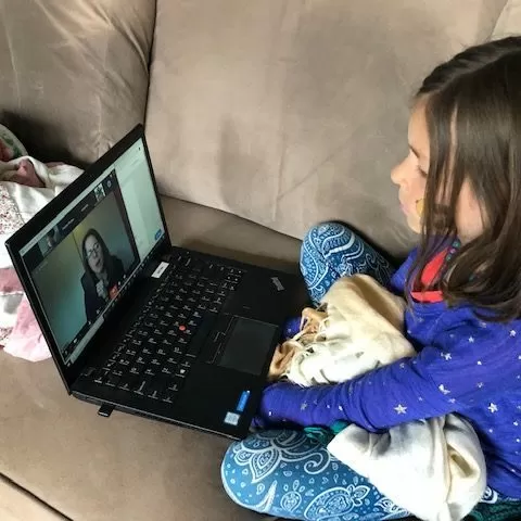 Child watching educational video on laptop
