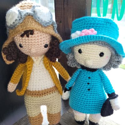 imagine that fibre arts Two crocheted figures, one with a blue garden-tea outfit, another in pilot's gear
