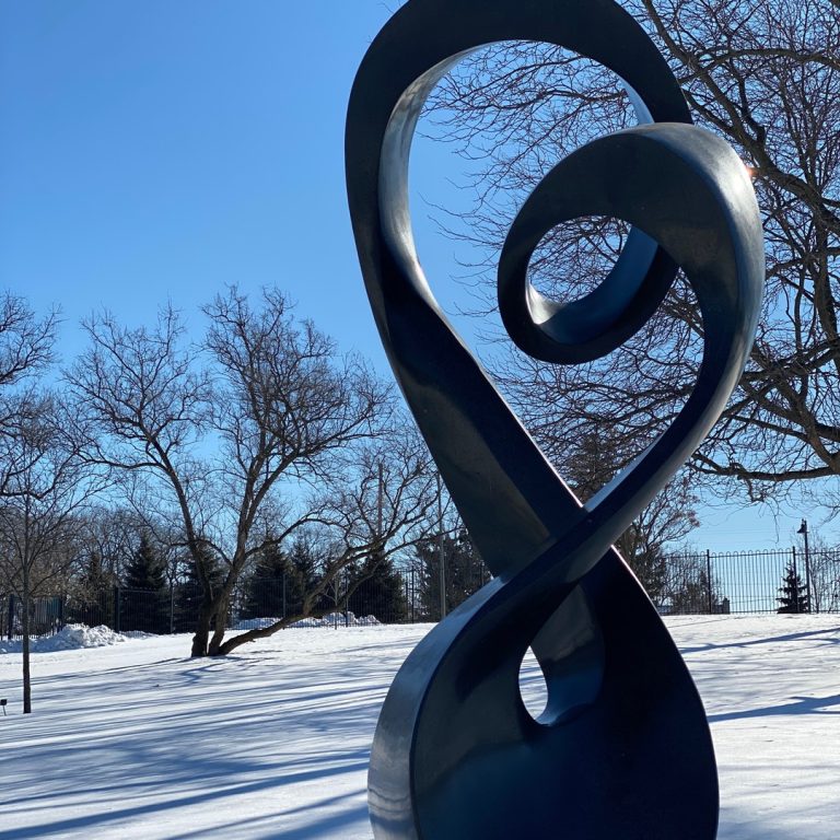 Tall black sculpture resembling a musical treble clef