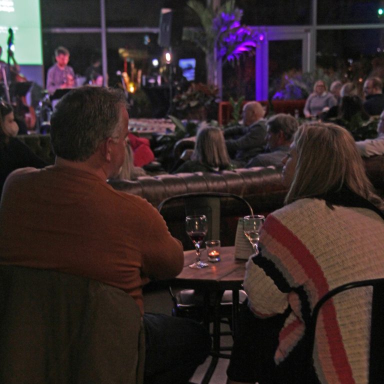 Couple at WinterTide enjoying a glass of wine and watching live music