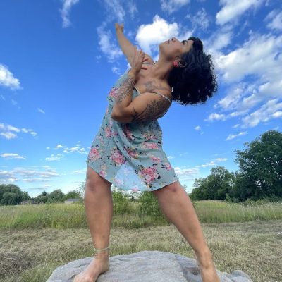 irma villafuerte irma villafuerte posing atop of a rock in a natural space, looking up towards the sky
