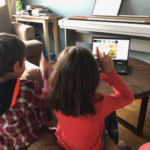 two kids watching a video on a laptop