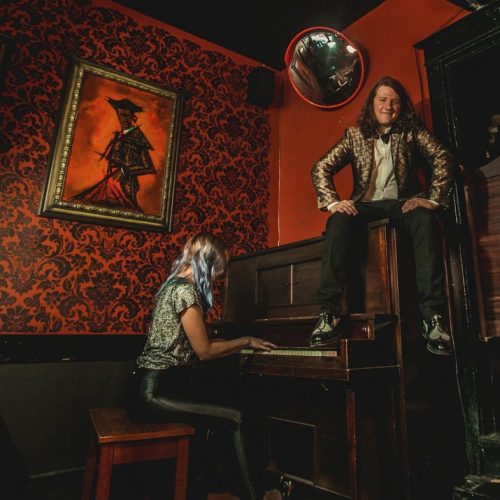 little magic sam sam sitting on top of a piano while someone plays the keys below