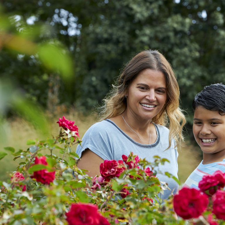 mother and daughter looking at red roses