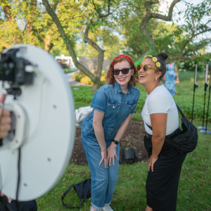 picture-us-photo-booth two women posing in front of a photo booth camera in a garden
