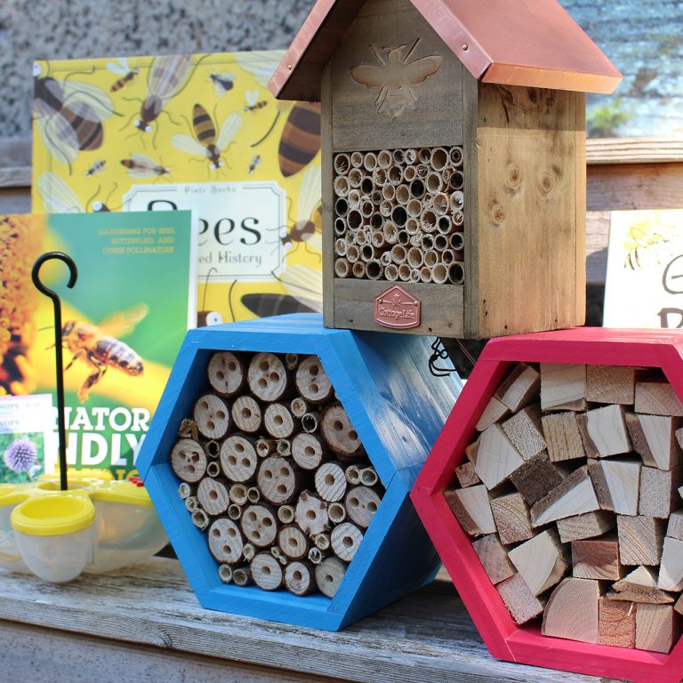 Selection of pollinator houses and related books from the shop