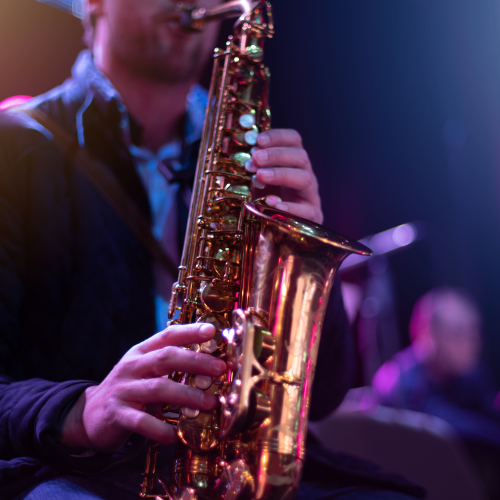 saxophone on stage Man playing saxophone on dimly lit stage