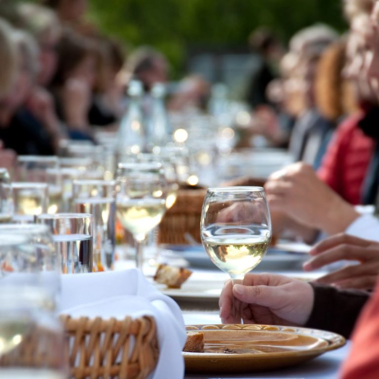 guests enjoying dinner at a long outdoor table